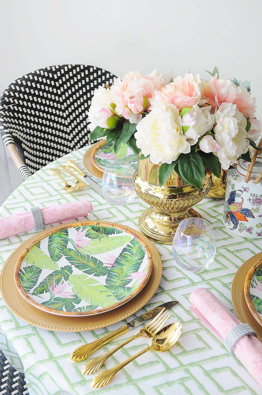 A small dining space centerpiece with major chinoiserie, Lilly Pulitzer and Palm Beach vibes. Featuring bamboo plates, gold chargers and flatware and pink peonies. A small dining space centerpiece with major chinoiserie, Lilly Pulitzer and Palm Beach vibes. Featuring bamboo plates, gold chargers and flatware and pink peonies.