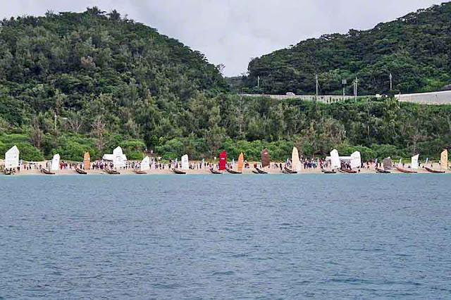 multi-colored sails, sabani boats, mountain, sky, beach, ocean