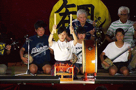 Band on stage, drummer girl, sanshin players