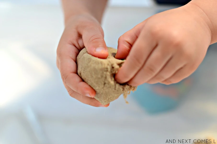 Preschool kid digging in kinetic sand