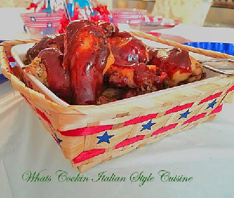 homemade barbecue sauce over chicken legs in a r ed white and blue basket for 4th of july picnic