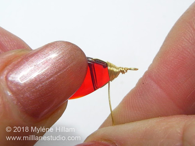 Wrapping the wire neatly around the top of the bead.