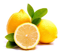 Bir tanesi yarıdan kesilmiş limonlar ve limon yaprakları