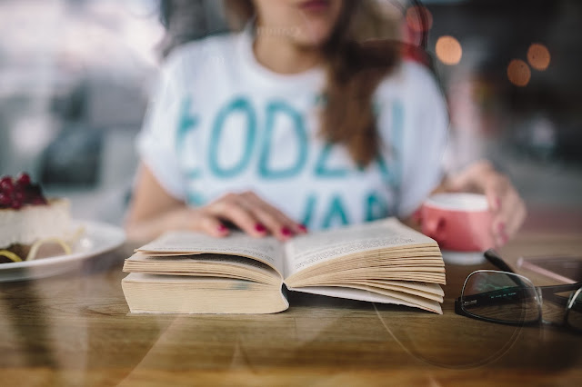 Foto do site Kaboompics Uma mulher jovem a ler num café