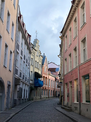 Kurvet gate mellom pastellfargede hus.