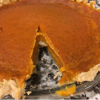 pumpkin pie with one slice taken out of it