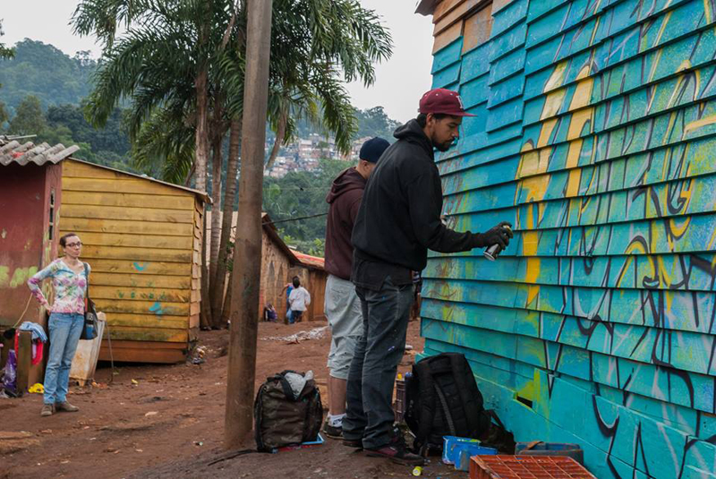 A bióloga Natasha Ceretti que estava pesquisando o TI Jaraguá observa o início da produção de um dos painéis de grafite. Foto: Nelson Luiz Batista A bióloga Natasha Ceretti que estava pesquisando o TI Jaraguá observa o início da produção de um dos painéis de grafite. Foto: Nelson Luiz Batista