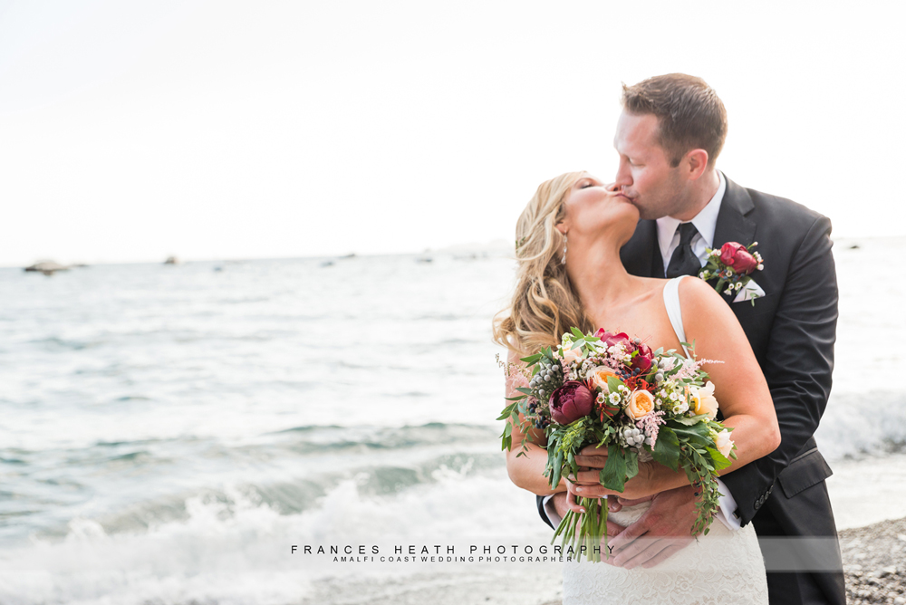 Bride and groom kissing on Positano beach