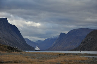Image of a boat on a lake surrounded by mountains 