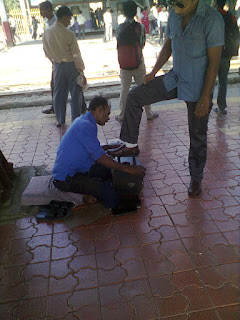 Shoe shine man polishing man's shoes at railway station, andheri bandra cst central railway, shoe polisher