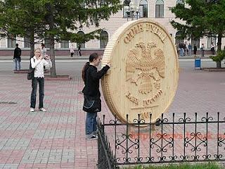Moneda gigante tallada en madera.