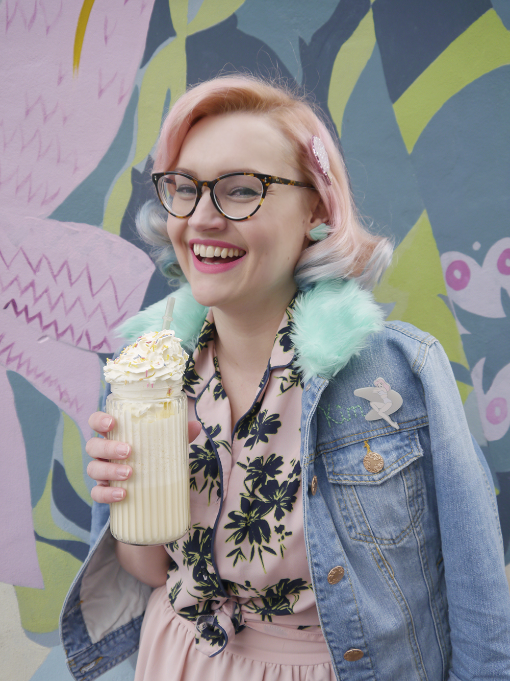 Laughing fashion blogger with retro diner style outfit and peanut butter milkshake with cream and sprinkles