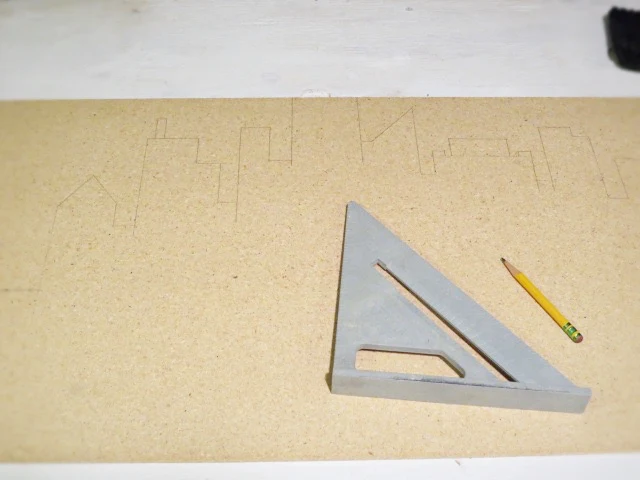 drawing up city scape on piece of wood