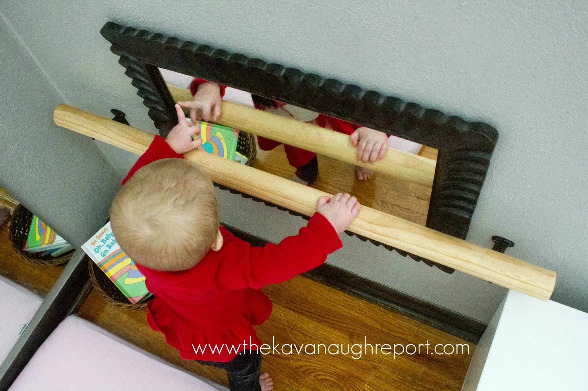 Montessori baby grabs onto DIY pull up bar