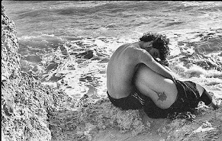 Imagen de un hombre abrazando a una mujer a orillas del mar
