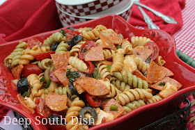 Pizza Pasta Salad ri-color rotini pasta is paired with some of my favorite pizza toppings, purple onion, green and red bell pepper, black olives, pepperoni, bacon, mushrooms, grape tomatoes and mozzarella and dressed with a spicy tomato dressing.