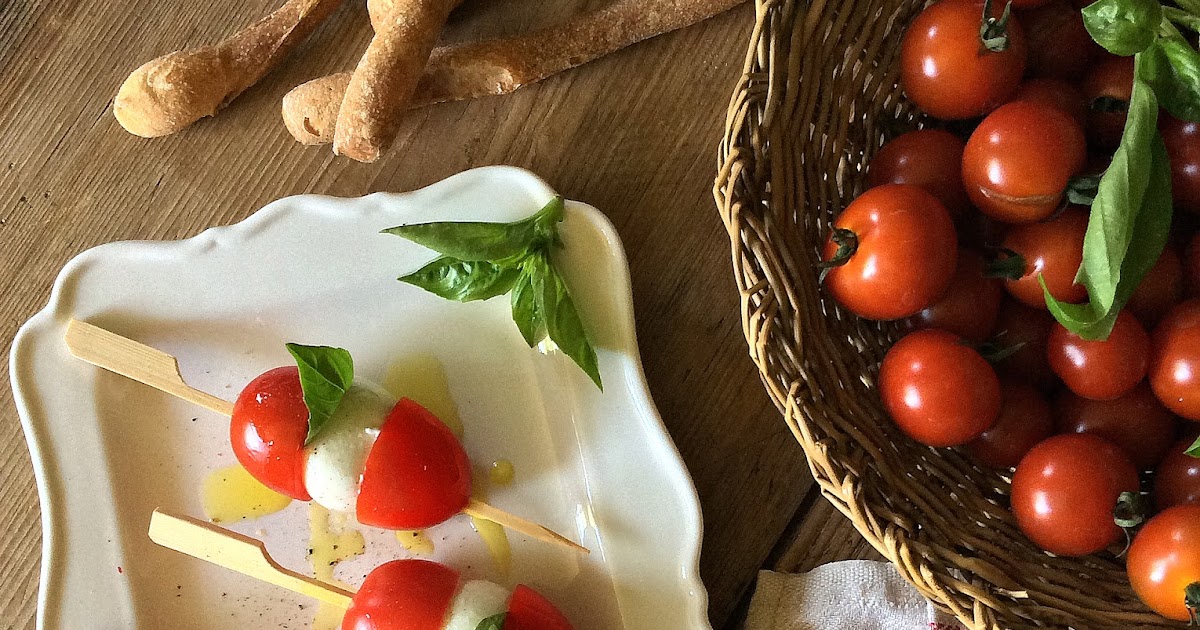 Spiedini mignon di pomodorini, mozzarelline e basilico. Immancabili tra