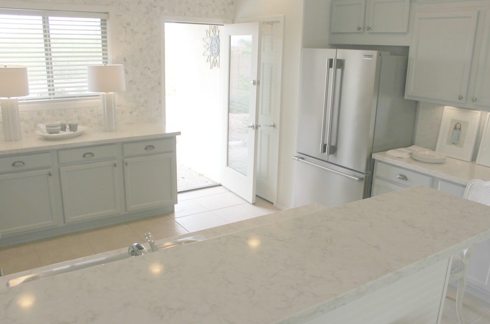 Modern farmhouse kitchen with grey cabinets, cup pulls, and quartz