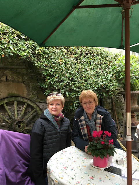 Wrapping Up England: Wendy and me at the Lavender Tea Rooms in Bakewell, Derbyshire, England two ladies in sweaters and scarves at an outdoor cafe table, under a green umbrella