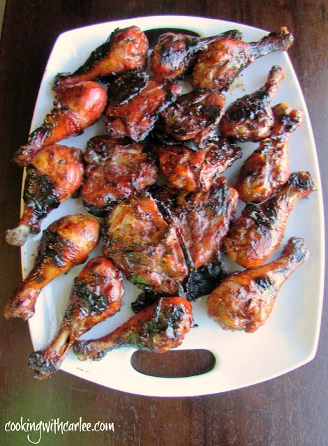 This fun grilled chicken recipe is based of char siu, the red pork you see at Chinese restaurants. It soaks for a long time in a great marinade giving it that color and tons of flavorful. platter of shiny red grilled chicken drumsticks and thighs