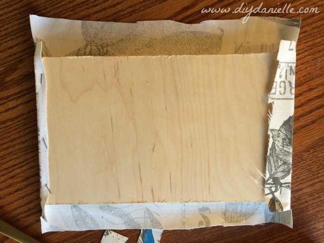 Use a staple gun to staple the fabric to the wood. Use a staple gun to staple the fabric to the wood.