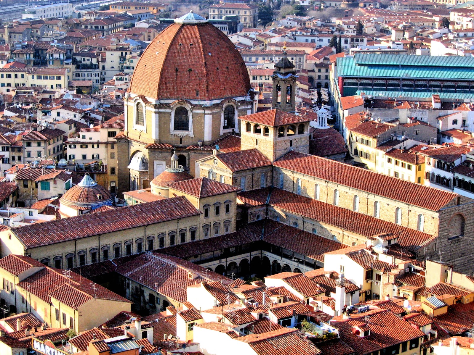 Aerial view of San Lorenzo. The section that extends from beneath the dome to the lower left is the Laurentian Library. Look carefully to the right of the dome, and you'll see the smaller dome of the Medici Chapel with white-marble cupola. Photo: WikiMedia.org.