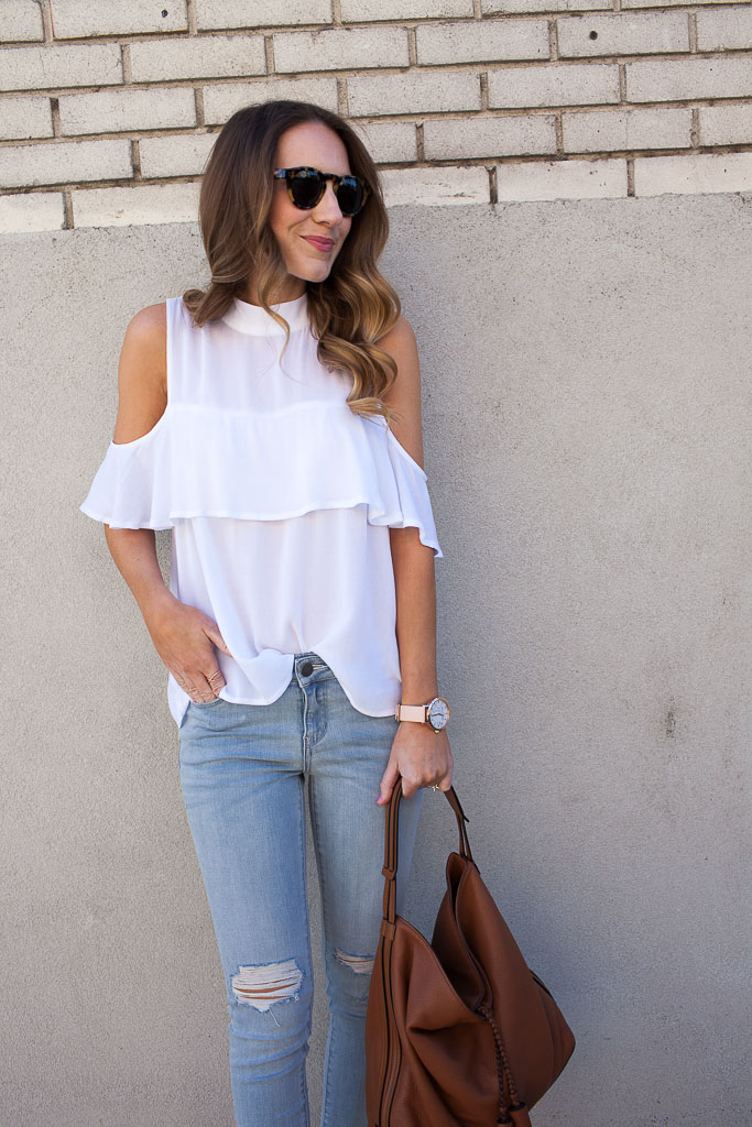 A cold shoulder ruffle top with distressed denim and espadrilles. 