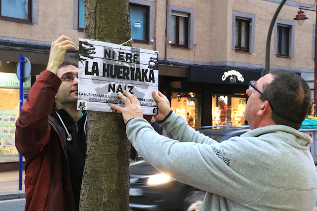 Activistas de La Huertaka colocan un cartel Encartelada contra el juicio a La Huertaka
