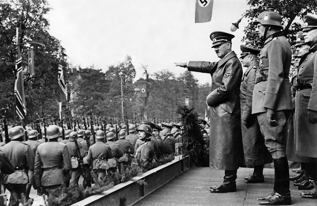 Adolf Hitler salutes parading troops of the German Wehrmacht in Warsaw, Poland, on October 5, 1939 after the German invasion. Behind Hitler are, from left to right: Colonel General Walther von Brauchitsch, Lieutenant General Friedrich von Cochenhausen, Colonel General Gerd von Rundstedt, and Colonel General Wilhelm Keitel.