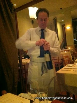 waiter opens wine at Capannina in San Francisco