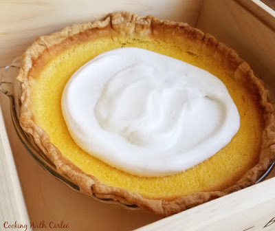 A smooth and luscious lemon pie topped with honey whipped cream is just what a hot day calls for. This may be your new favorite summer pie. whole lemon pie with cloud of honey whipped cream in the center