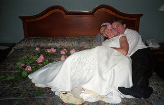 pareja de novios en una cama con rosas. Habitación kistch