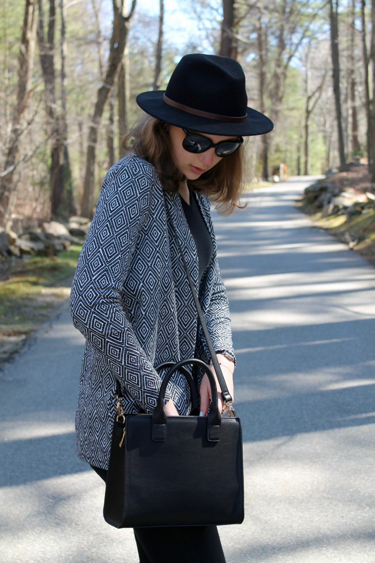 patterned black and white jacket and black bag