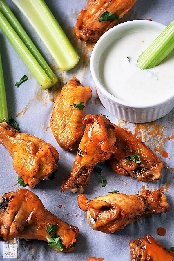 Tray of low carb buffalo wings with Gorgonzola dipping sauce ready to eat with a side of celery sticks