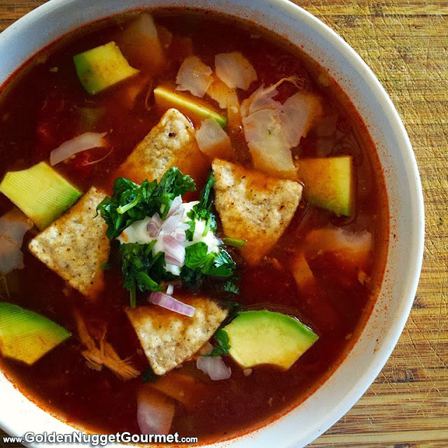 Chicken tortilla soup in a bowl topped with cilantro and sour cream