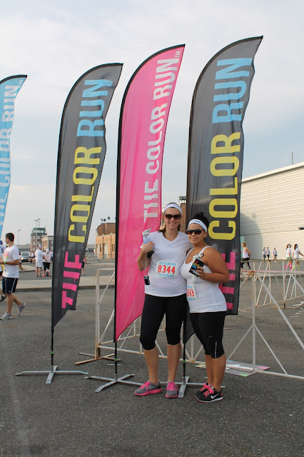 Two women smiling and posing for a photo before the start of a color run