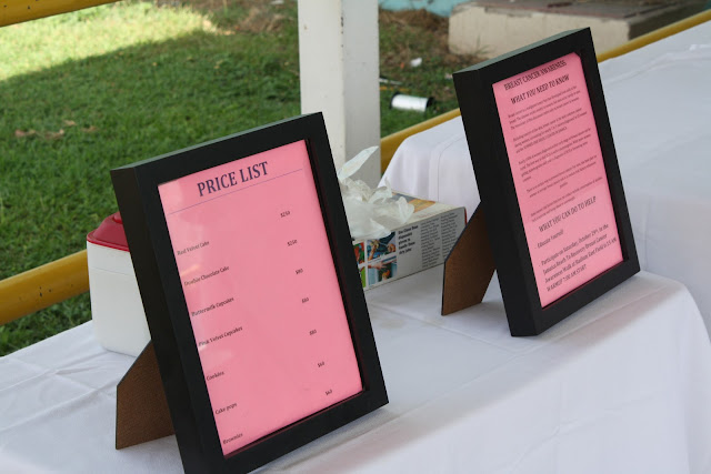 Two framed price lists on a white table.