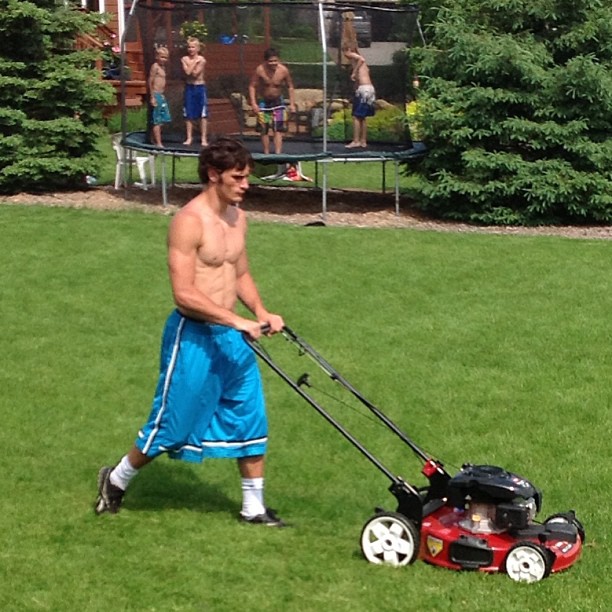 Hot gardener lawn mowing.