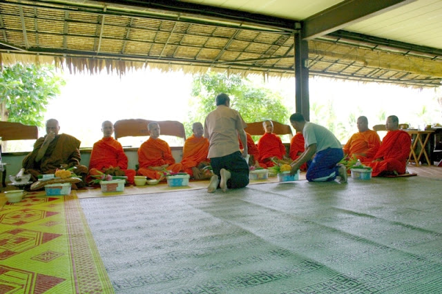 Ten Buddhist monks are hired to perform ceremonial chants and blessings for Nid and family.