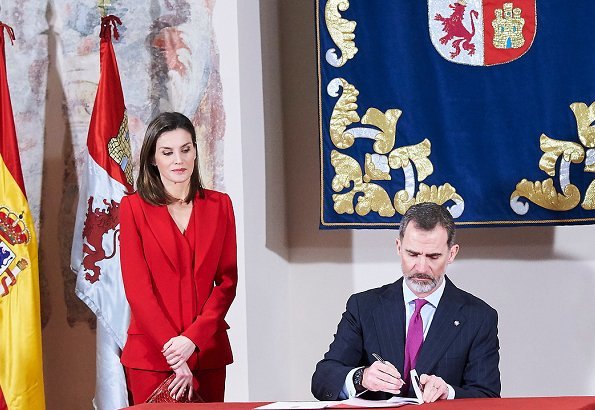 Queen Letizia wore Roberto Torretta red suit from Fall Winter 2017 2018 collection. She wore Magrit pumps and Carolina Herrera print clutch bag