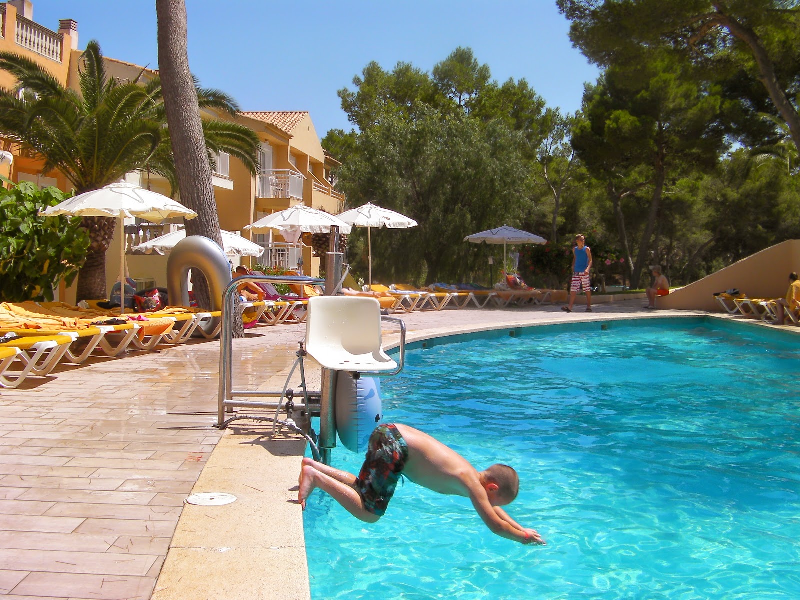 boy diving into swimming pool on first day of holiday cala barca hotel pool portopetro santanyi majorca