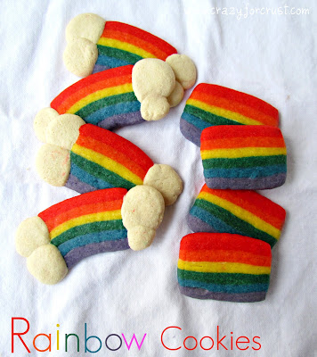 sugar cookies dyed rainbow colors with white clouds at ends on white linen with words