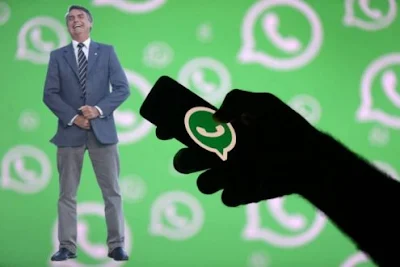 Bolsonaro rindo com logos do WhatsApp