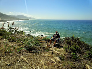 A cyclist, before the fever struck, taking a break by the sea and in the sunshine.