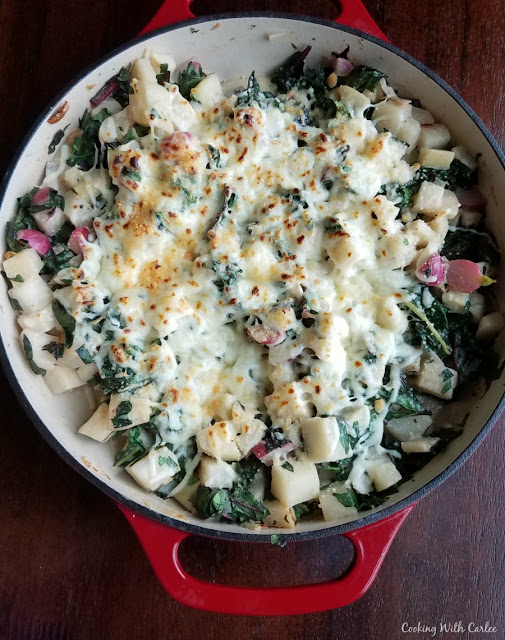Tender spring vegetables in a creamy sauce and topped with golden melted cheese. Spring vegetables au gratin is sure to become your favorite veggie side dish! pan full of spring vegetables au gratin