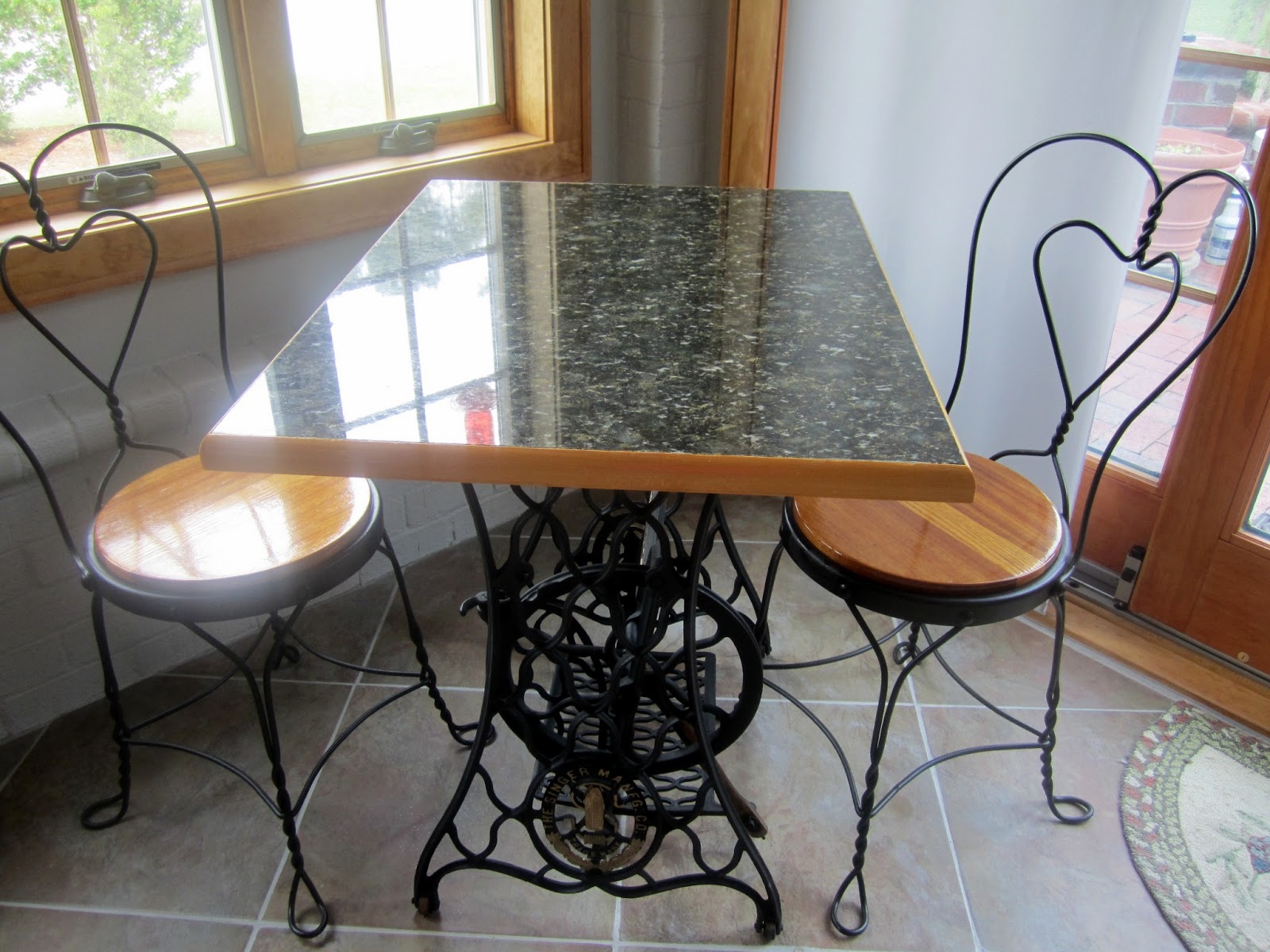 The Bear Cupboard GRANITETOPPED TABLE WITH ANTIQUE SEWING MACHINE