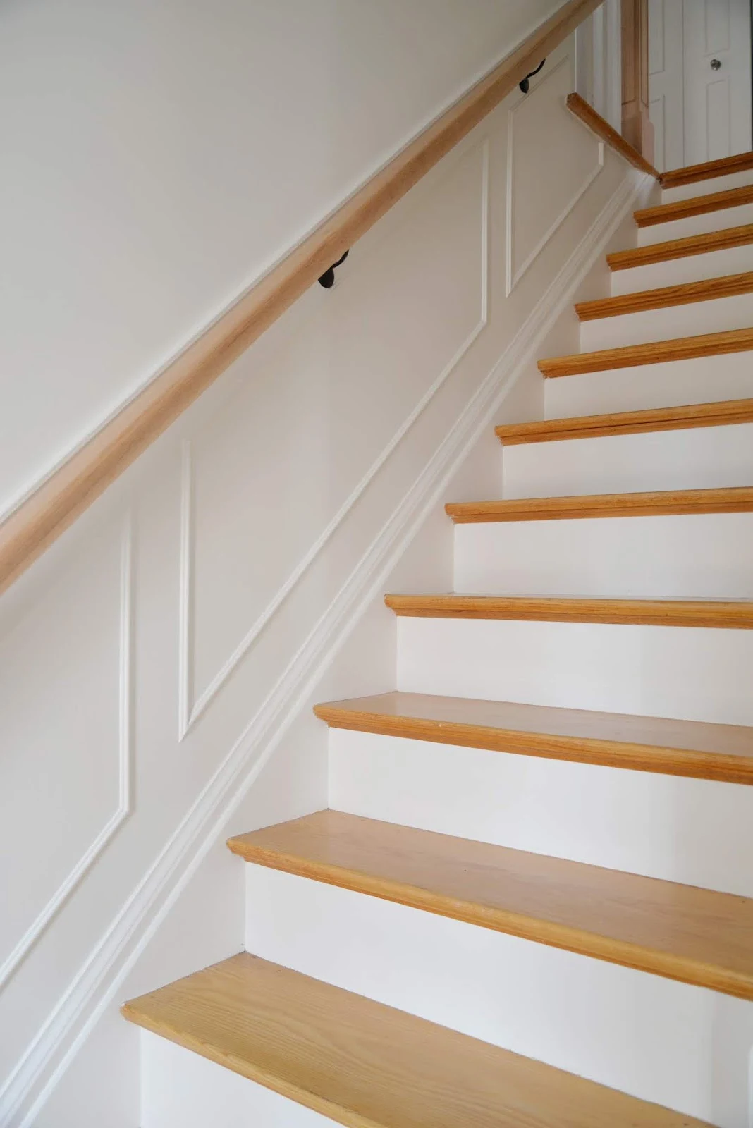 stairway with white walls, moulding, white risers and natural stair treads
