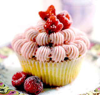 raspberry cupcakes decorated with pink raspberry icing and garnished with fresh raspberries