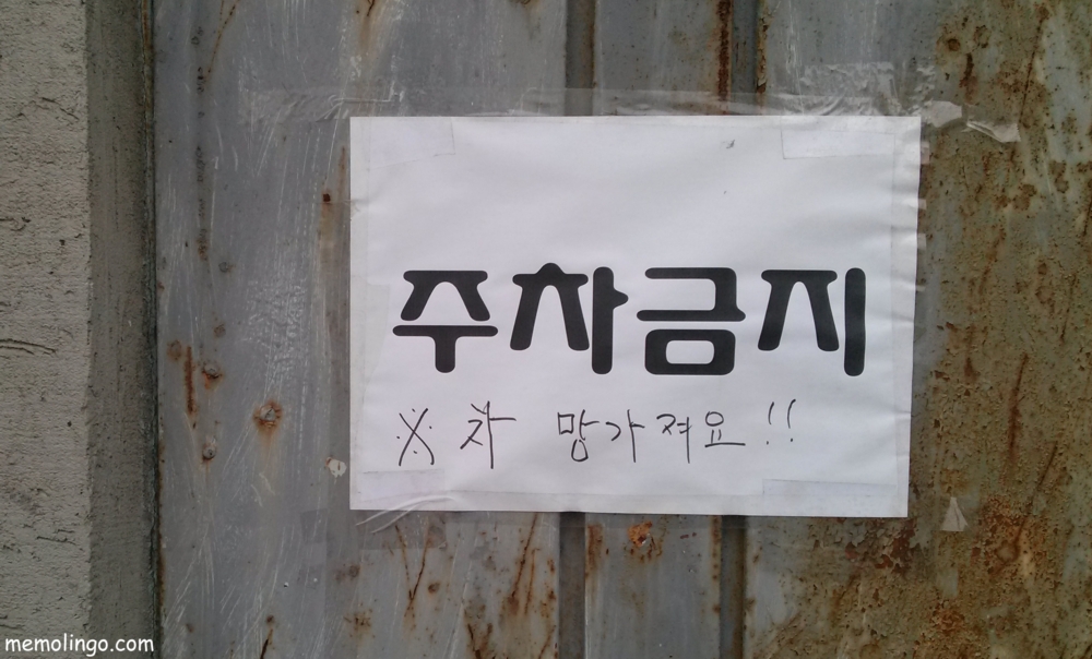 Cartel amenazante de prohibido aparcar en coreano