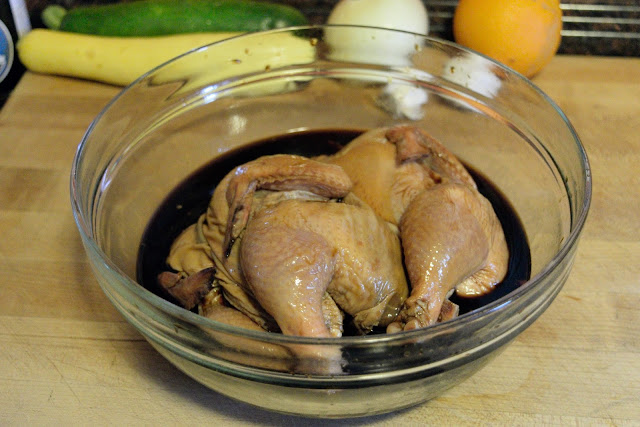The Cornish Hens , butterflied, in the bowl of marinade.